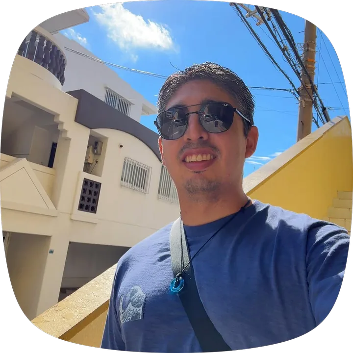 Milton Aguirre smiling in sunglasses on a sunny street